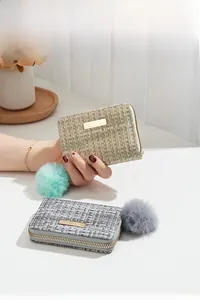 Close-up of woven tweed card holders in green and gray with fluffy pompom charms