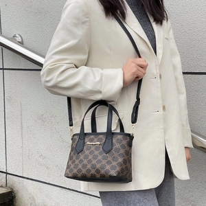 Braune Monogramm-Eimertasche für Damen mit schwarzen Ledergriffen und Schulterriemen