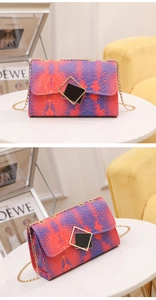 Detailed close-up of textured snakeskin pattern and gold geometric clasp on luxury bag