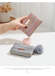 Detail of woven texture women's short wallet with gold hardware and fluffy pompom charm