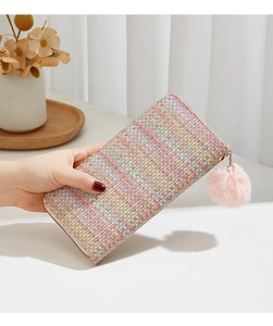 Détail du portefeuille tissé coloré avec texture tweed et pompon en peluche rose