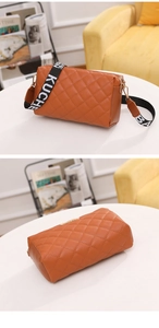 Detailed close-up of brown quilted PU leather handbag with wide embroidered strap