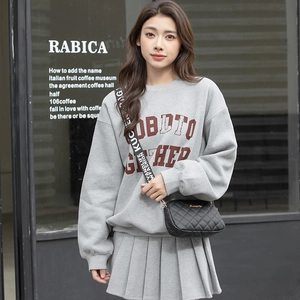 Fashionable black quilted camera bag with white letter strap on grey casual sweatshirt