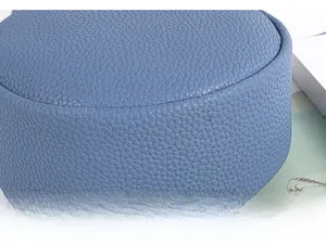 Detailed macro view of reinforced stitching on blue lychee pattern leather bag bottom