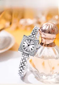 Macro view of vintage square silver watch with rhinestone bezel and fish scale strap