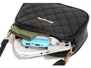 Détail du sac bandoulière matelassé noir montrant le rangement intérieur pour mobile et porte-monnaie