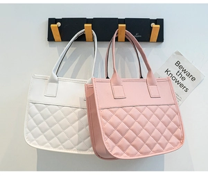 Detail showing white and pink tote bags with classic quilted diamond pattern and top handles
