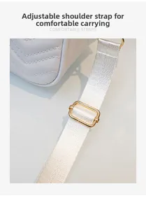 Détail de la bandoulière réglable avec boucle dorée sur un sac à bandoulière matelassé blanc