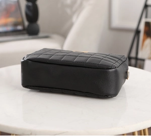 Detail of side view showing quilted black PU leather bag with gold metal D-ring attachment