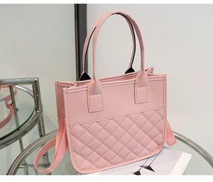 Detail of light pink tote bag featuring diamond quilted texture and detachable strap
