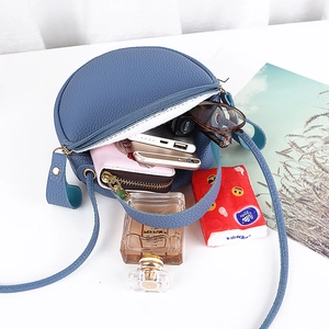 Sac à bandoulière rond en cuir bleu avec texture litchi et rangement intérieur spacieux