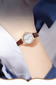 Detailed close-up of a luxury women's quartz watch with a diamond bezel and brown leather strap