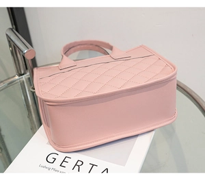 Close-up of pink quilted handbag with elegant stitching on a glass surface display