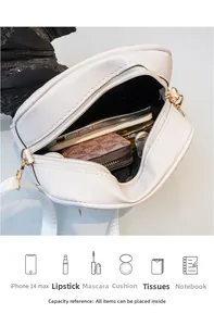 Intérieur du sac à bandoulière rond blanc montrant l'espace pour téléphone et cosmétiques