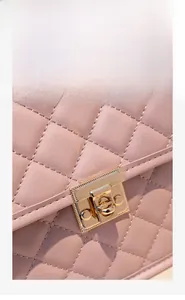 Close-up of a pink quilted backpack featuring a polished light gold metal clasp lock