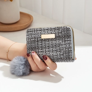 Chic grey woven card holder with gold hardware and a decorative grey fur pompom charm