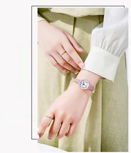 Primo piano di un orologio al quarzo minimalista con cinturino in pelle rosa e numeri romani