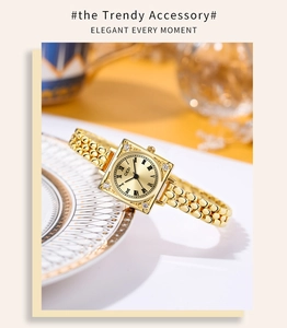 Detail of square gold watch with crystal accents on a white porcelain dish