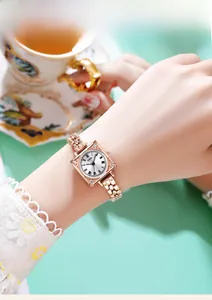Close-up of a vintage rose gold square watch with roman numerals and beaded metal strap