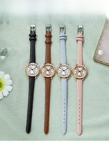 Flat lay of four colorful quartz watches with leather straps on a soft textured background
