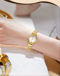 Close-up of a luxury vintage women's gold quartz watch with minimalist round white dial