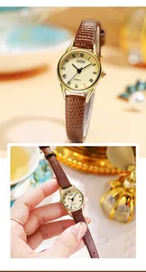 Gros plan d'une montre à quartz dorée vintage avec chiffres romains et bracelet en cuir brun