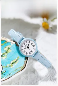 Dettaglio dell'orologio al quarzo azzurro minimalista con numeri romani e quadrante bianco
