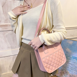 Sac à main en cuir matelassé rose avec bandoulière porté par un mannequin en mode
