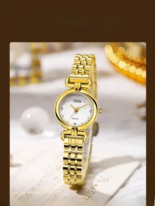 Close-up of gold quartz watch with crystal indices and radial textured white dial