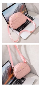 Detail of pink quilted crossbody bag featuring a golden floral clasp and nylon strap