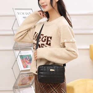 Chic black quilted crossbody bag for women featuring a sleek gold metal bar accent