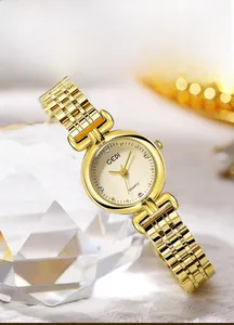 Detailed view of GEDI gold quartz watch with textured dial on crystal props