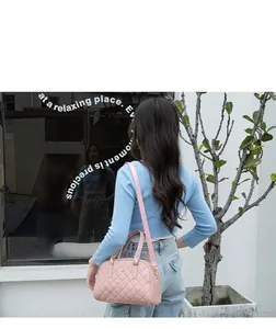 Vista posteriore di una borsa rosa in pelle PU trapuntata con logo dorato e tracolla