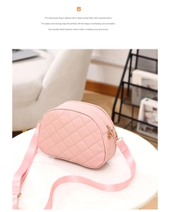 Macro view of soft pink quilted shell bag with metallic gold hardware and fabric strap