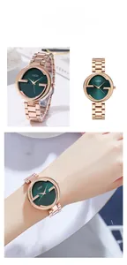 Détail d'une montre à quartz rose doré avec cadran vert émeraude et logo G évidé