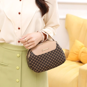 Sac à main marron avec monogramme et rabat beige en cuir présenté par un mannequin
