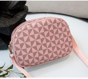 Détail du sac bandoulière rose avec motifs géométriques et fermeture éclair dorée