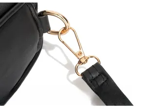 Détail de la boucle en métal doré et des coutures sur un sac en cuir matelassé noir