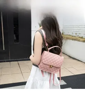 Outdoor shot of a pink quilted mini backpack with golden lock and adjustable straps
