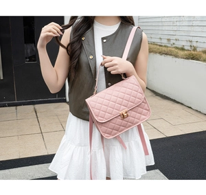 Detail of pink quilted flap backpack with golden twist lock and fine leather texture