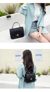 Detail of black quilted backpack featuring a gold metal lock and elegant top handle