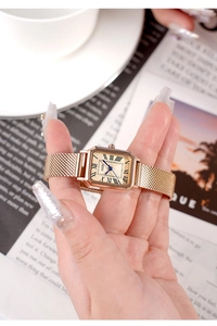 Macro detail of GEDI square gold watch with Roman numerals and blue hands