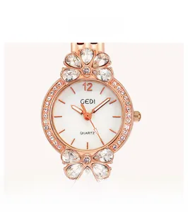 Dettaglio macro della cassa dell'orologio a fiore in oro rosa con cristalli bianchi