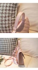 Detail of pink quilted texture backpack with gold hardware and woven strap in warm setting