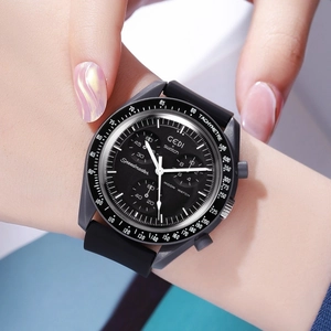 Close-up of black chronograph watch with silicone strap on wrist showing sporty dial