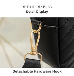 Detail of high-gloss gold spring clip and black chevron quilted leather strap