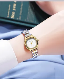 Elegant woman wearing a gold and silver stainless steel watch with white sunray dial