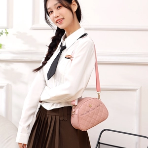 Pink quilted half-moon crossbody bag with gold hardware shown on a model for daily wear