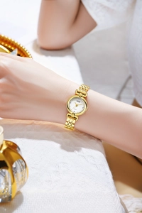 Macro shot of GEDI women gold watch with chain strap and elegant white lace background