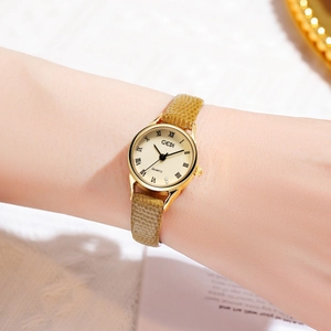 Gros plan d'une montre vintage dorée pour femme avec chiffres romains et bracelet en serpent